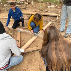 children building a catapult in a field